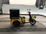 a yellow scooter with a black box on the back of it