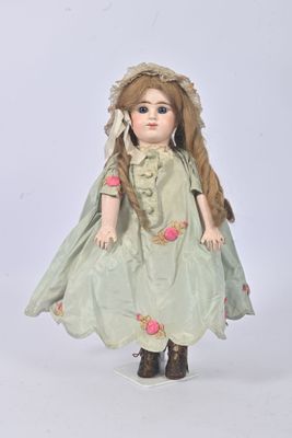 a doll that is dressed in a green dress and hat