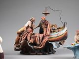 three figurines of people in a boat on a table