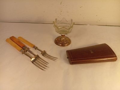 deux fourchettes, un couteau et un étui posés sur une table