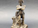 statue of a man sitting on a stump with a dog on his lap
