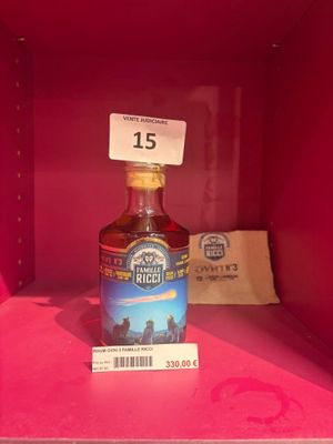 une bouteille d'alcool dans une boîte rose sur laquelle est apposée une étiquette de prix