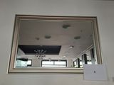 a mirror on the wall above a fireplace in a living room