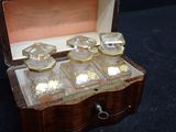 a small wooden box with six glass bottles in it