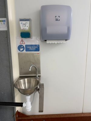 a sink and a hand dryer on the wall