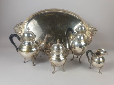 a silver tea set on a table with a mirror in the background