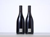 two bottles of wine sitting on top of a table next to each other