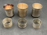 several silver cups and cups are sitting on a table