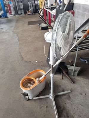 une photo représentant un ventilateur et un seau dans un garage