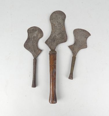 three old metal tools on a white surface with a white background