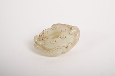 une image représentant un petit objet sculpté sur une surface blanche