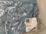 a blue t - shirt wrapped in plastic on a table