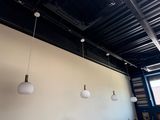 three lights hanging from the ceiling of a restaurant