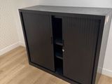 une armoire noire surmontée d'un miroir