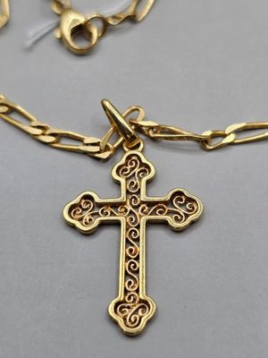 Gros plan sur un collier en or orné d'une croix