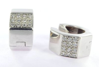 une paire de boucles d'oreilles en or blanc et diamants sur fond blanc