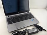 an open laptop computer sitting on top of a table next to a charger