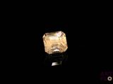 a close up of a yellow diamond on a black surface