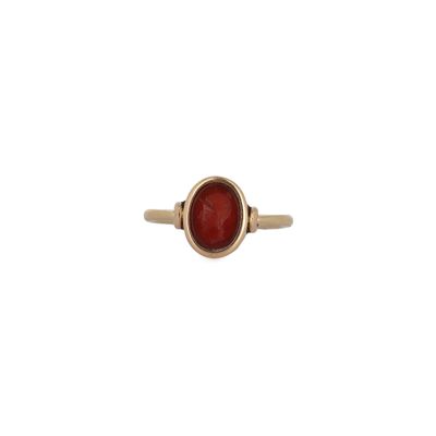 une bague en or avec une pierre rouge au centre
