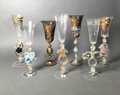 several glass goblets and wine glasses are lined up on a table