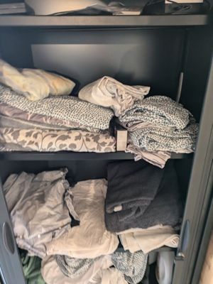 a cabinet with a lot of clothes on it