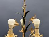 a chandelier that has a light bulb and flowers on it