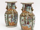 pair of chinese vases with figures on them on a white background