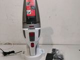 a vacuum that is sitting on the floor next to a charger