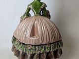 a figurine of a woman in a dress and hat