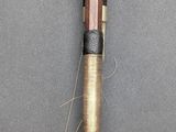 an image of a pen with a wooden handle on a gray surface
