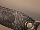 a close up of a black leather bag with a metal handle