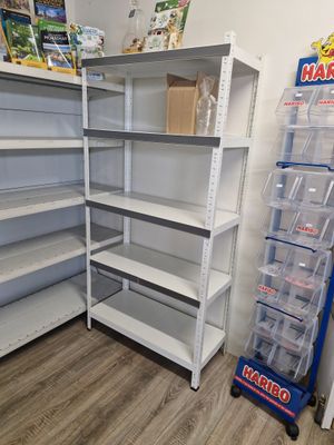 de nombreuses étagères dans un magasin, sur lesquelles sont posés des bacs en plastique