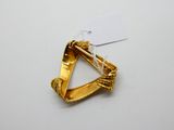 une photo d'une broche en forme de triangle en or, sur laquelle est accrochée une étiquette