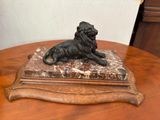une statue représentant un lion assis sur une table en bois