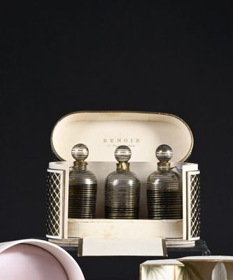 three bottles of perfume sitting in a case on a table