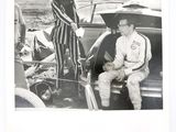 une photo en noir et blanc d'un homme et d'une femme assis dans une voiture