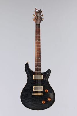 une guitare électrique suspendue à une ficelle sur un mur blanc