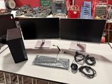 two computer monitors and a keyboard on a table