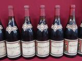 six bouteilles de vin sont alignées sur une table rouge