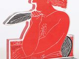 a red and black sculpture of a woman holding a feather