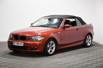 une photo d'une BMW décapotable rouge garée sur un sol à damier