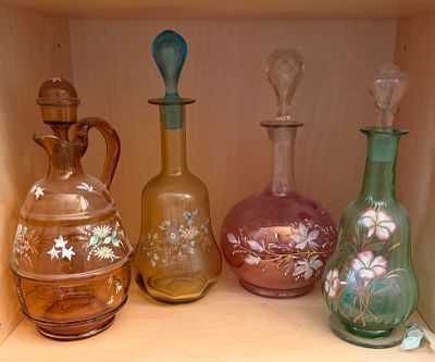many different colored glass vases sitting on a shelf