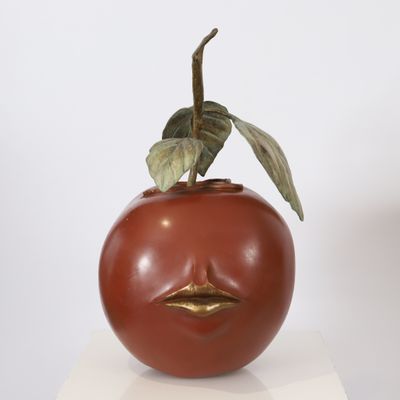 a sculpture of a tomato with a face on it