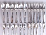 a lot of silver spoons and forks on the table