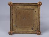 an image of a small bronze clock with a square face