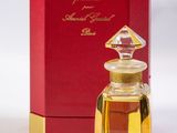 an image of a bottle of perfume next to a red box