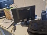 a black bag sitting on a desk next to a computer monitor