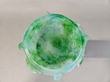 a glass bowl with a green substance inside of it