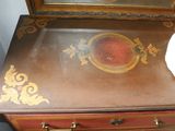a small wooden dresser with a mirror on top of it