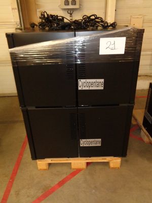 a stack of black boxes sitting on a pallet in a warehouse